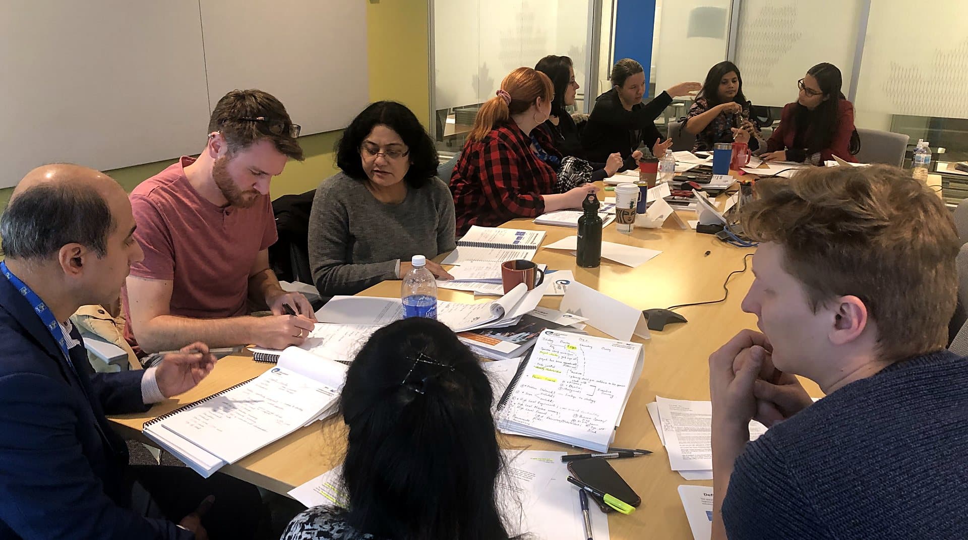 A small advisory group working through documents together at a table.